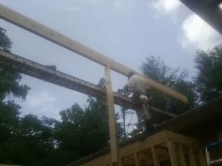 Carpenter setting a ridge beam over a new addition frame — Ice Dam Removal by Roofing Brothers in Etlan