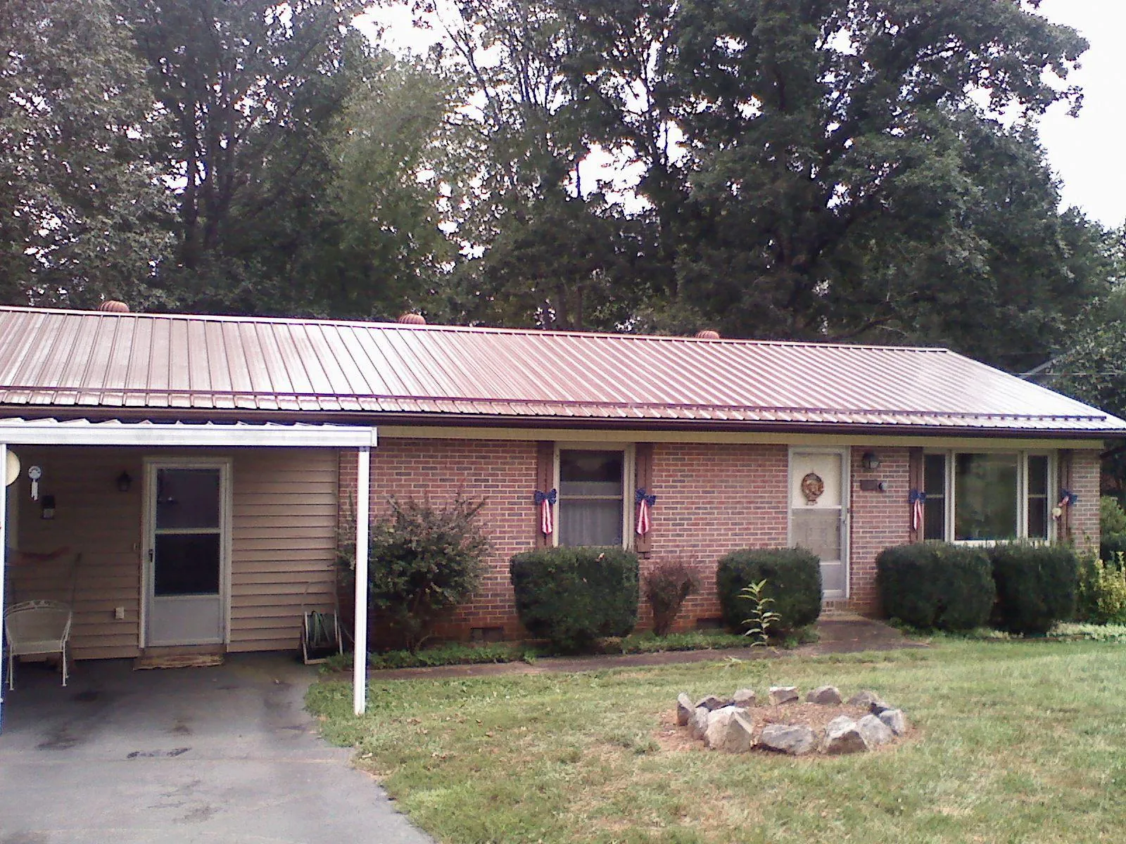 Bronze metal roof and carport on a brick ranch home — Roof Repair work by our crew in Etlan