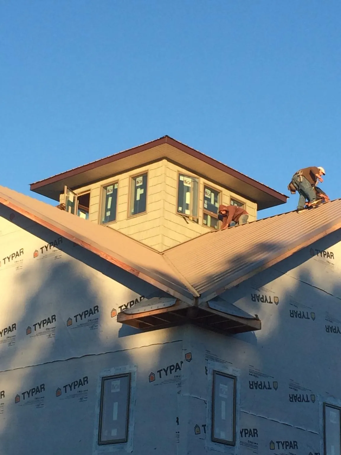 Roofers working around a rooftop cupola on a new metal roof at sunset — Roof Waterproofing in Etlan by Roofing Brothers